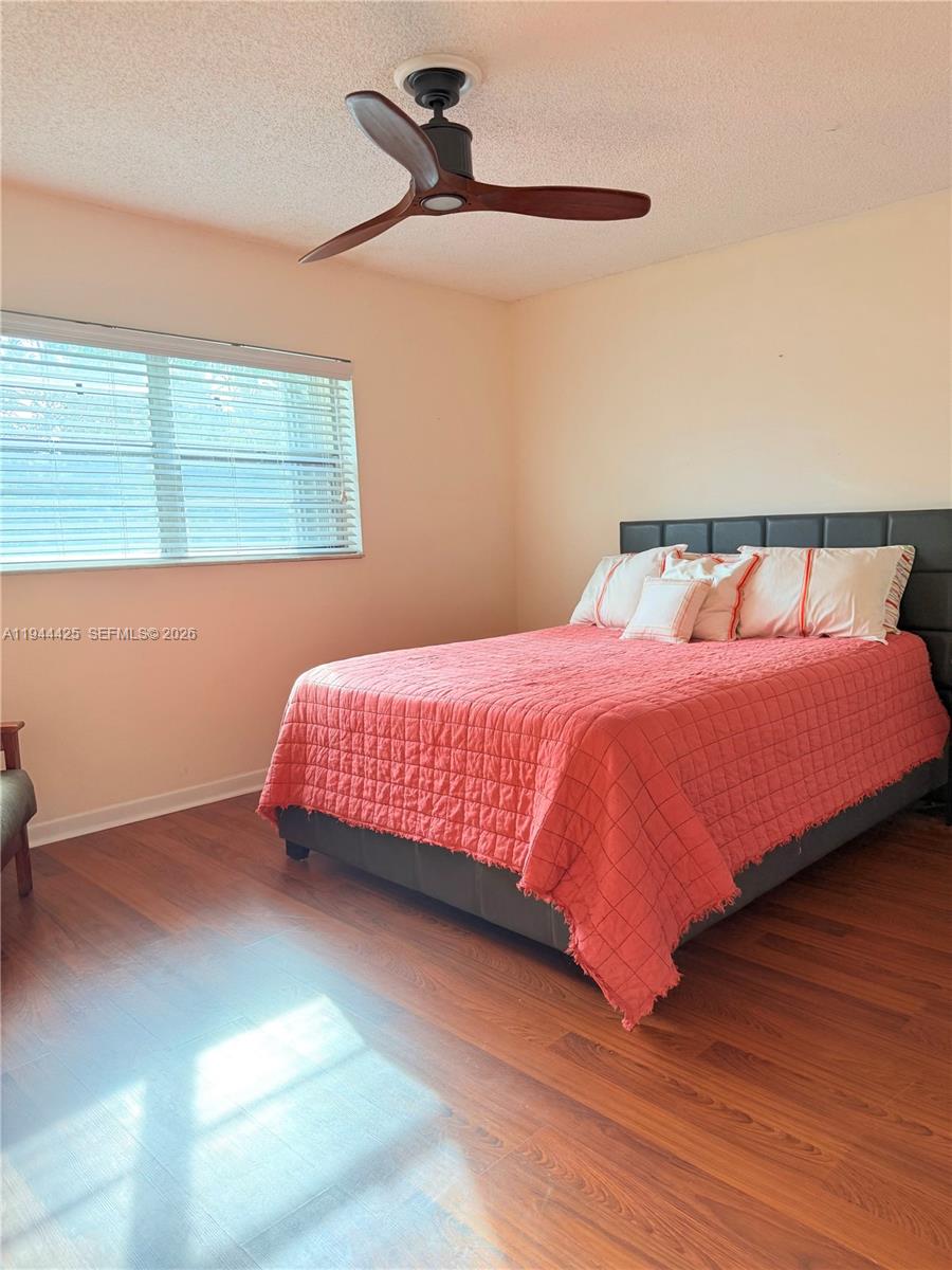 8951 North New River Canal Road, Unit 2D Plantation, FL 33324 - Photo 16 of 30 a bedroom with a bed and wooden floor