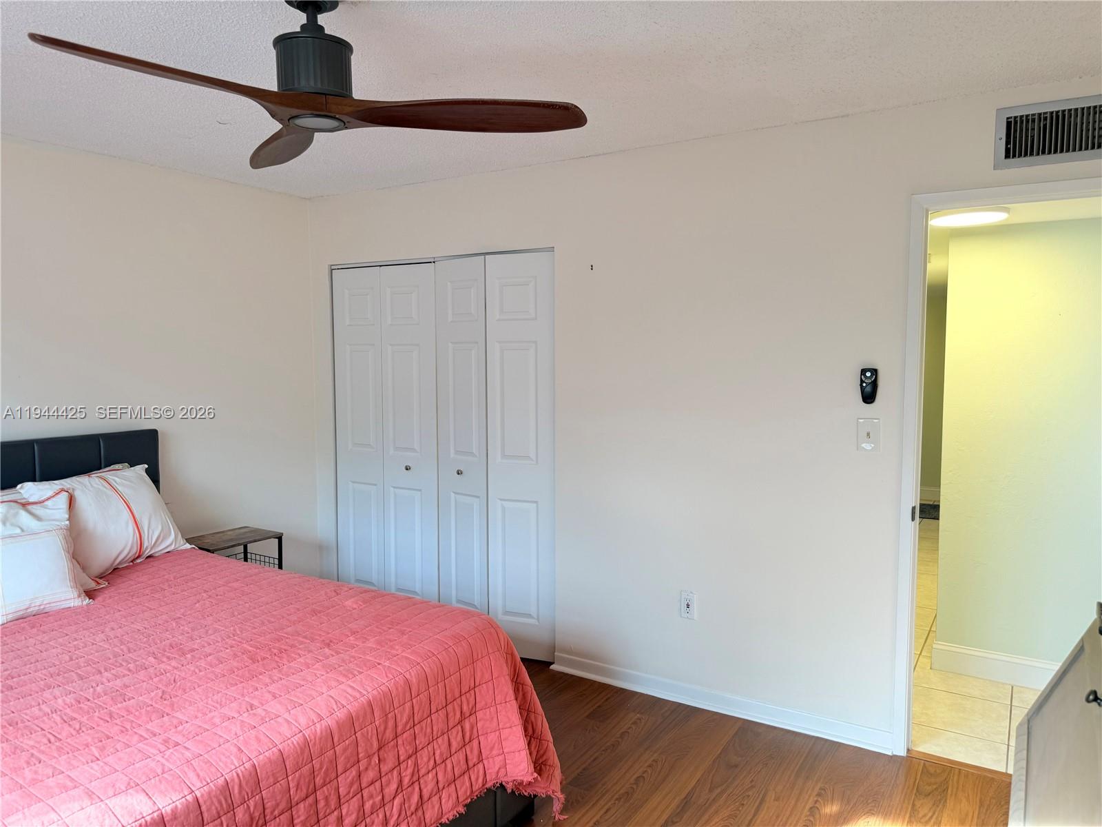8951 North New River Canal Road, Unit 2D Plantation, FL 33324 - Photo 17 of 30 a bedroom with a bed and a wooden floor