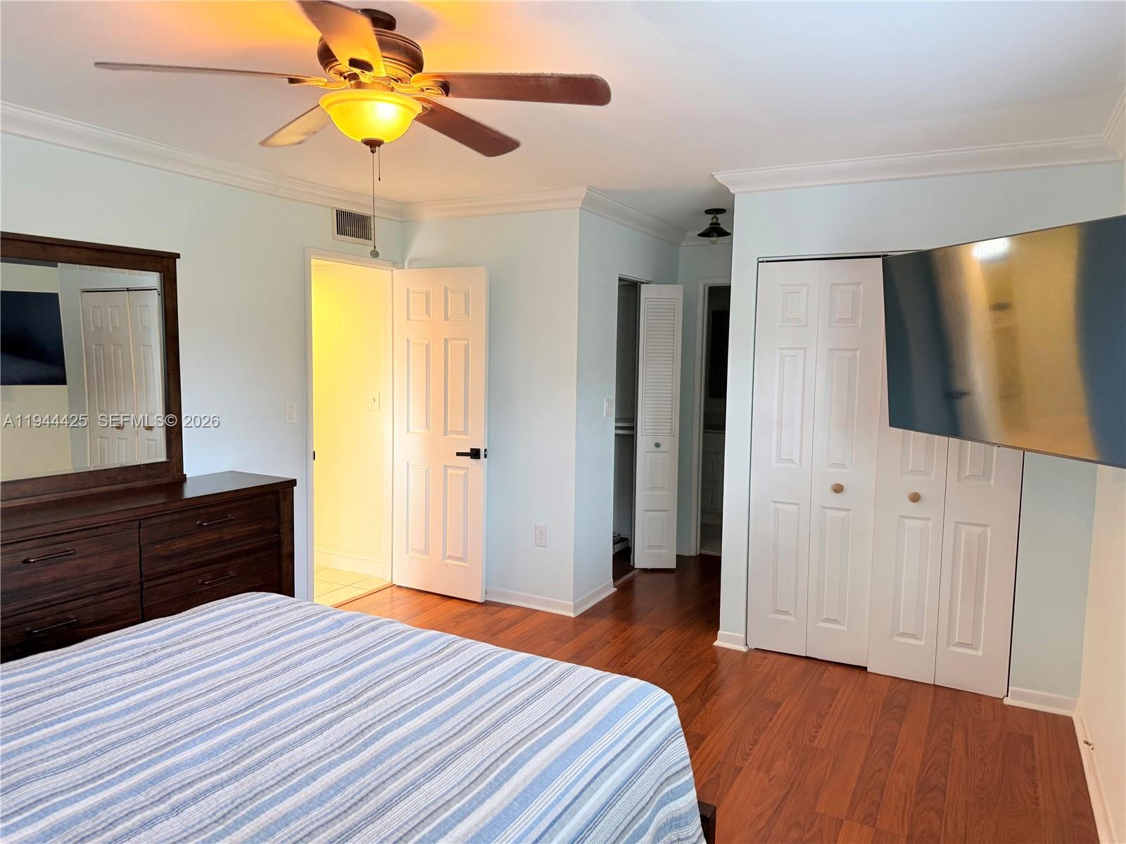 8951 North New River Canal Road, Unit 2D Plantation, FL 33324 - Photo 20 of 30 a bedroom with a bed and a flat tv screen on dresser