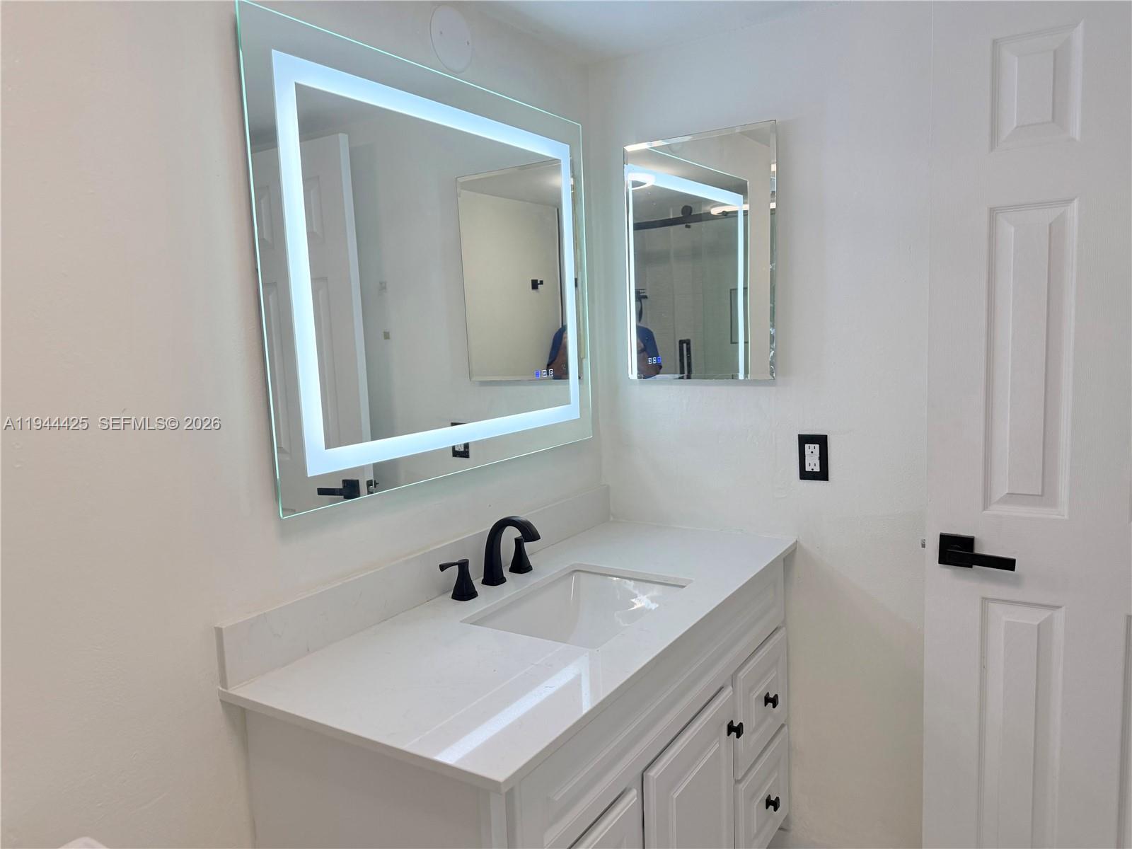 8951 North New River Canal Road, Unit 2D Plantation, FL 33324 - Photo 25 of 30 a bathroom with a sink and a mirror
