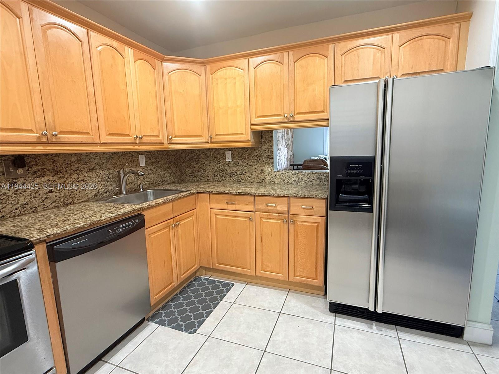 8951 North New River Canal Road, Unit 2D Plantation, FL 33324 - Photo 10 of 30 a kitchen with stainless steel appliances granite countertop a refrigerator sink and cabinets