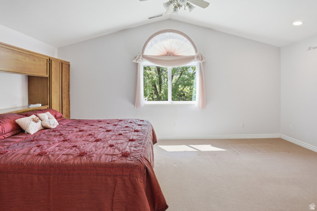 2190 750 West Perry, UT 84302 - Photo 31 of 42 Vaulted ceiling bedroom featuring a large arched window, built-in wooden cabinetry, recessed lighting, and a ceiling fan