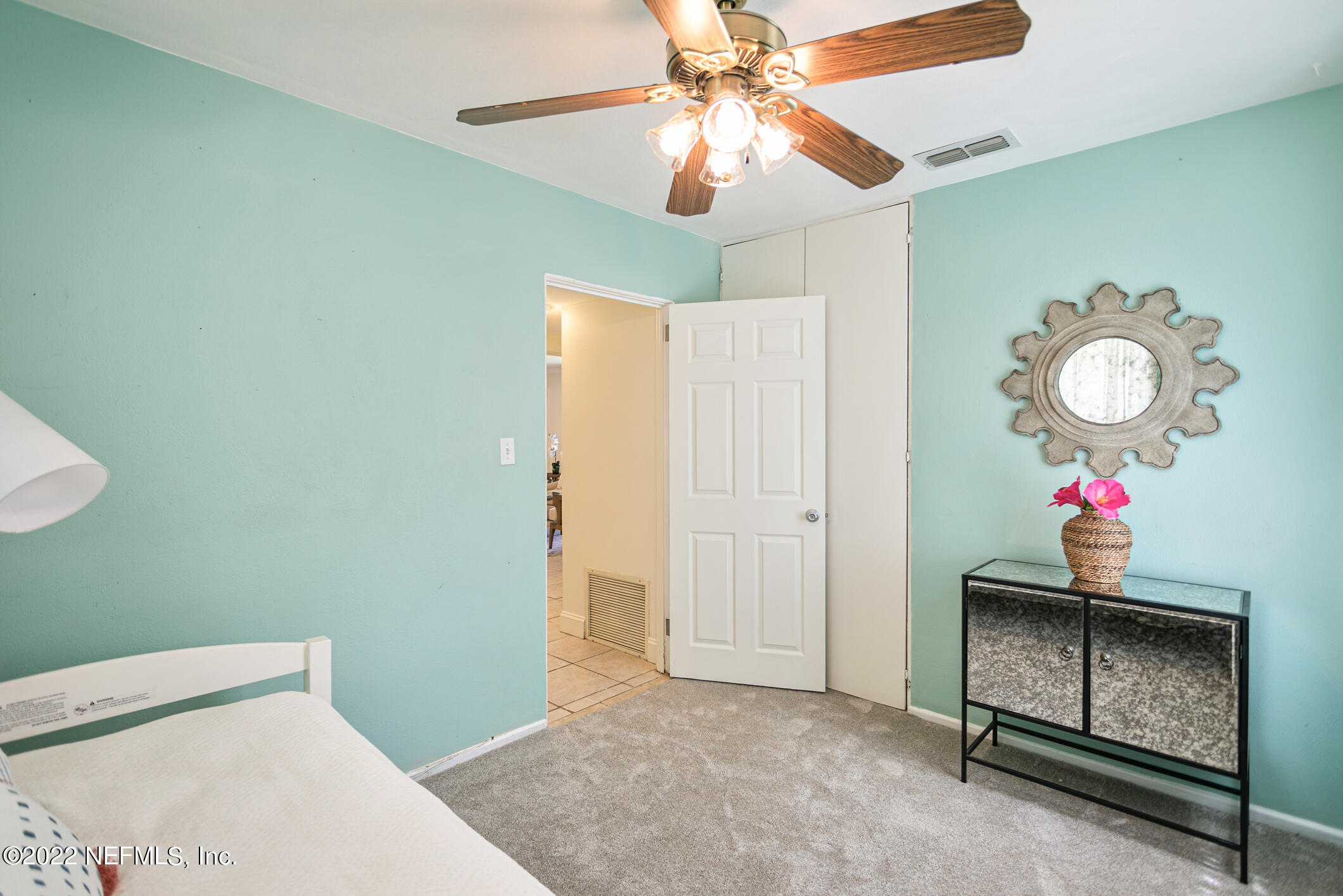 4631 Tanbark Road Jacksonville, FL 32210 - Photo 20 of 27 a bedroom with a bed and a chandelier