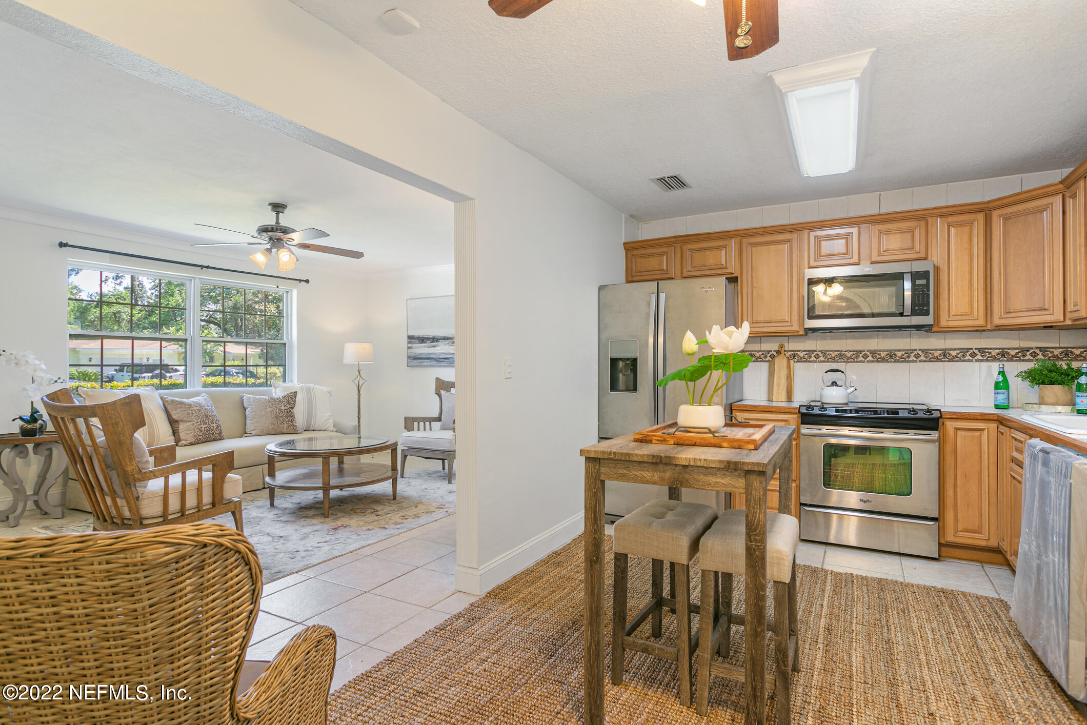 4631 Tanbark Road Jacksonville, FL 32210 - Photo 7 of 27 a living room with stainless steel appliances granite countertop furniture a fireplace a flat screen tv and a window