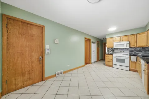 a large white kitchen with a sink dryer and cabinets