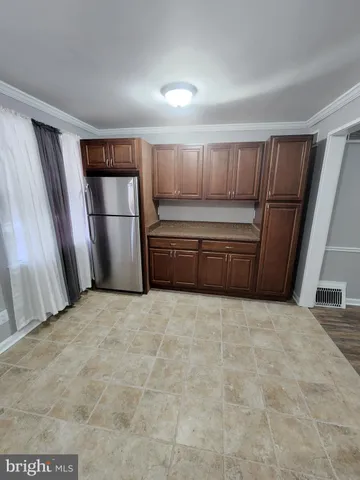 a view of kitchen with refrigerator and cabinet