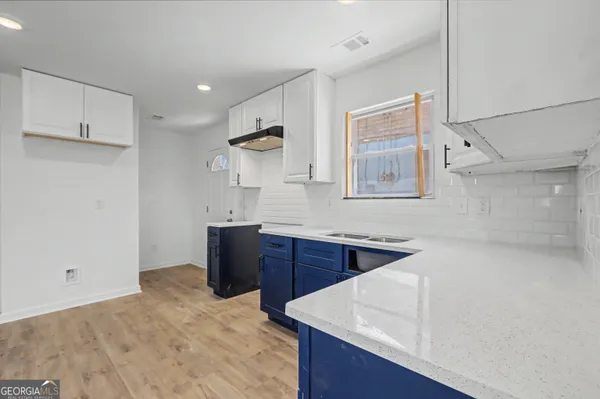 an empty room with wooden floor ceiling fan and window