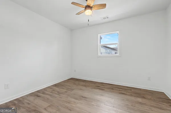 a view of an empty room with a chandelier fan