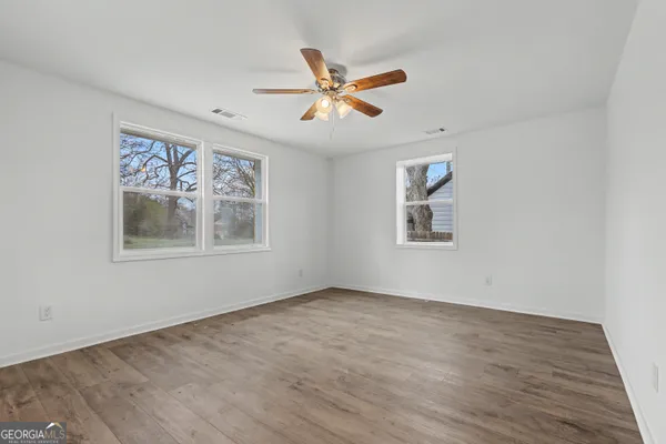 an empty room with fan and windows