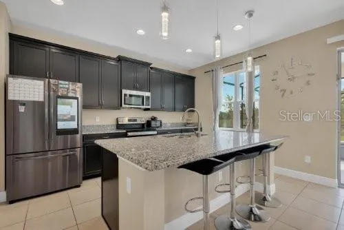 a kitchen with kitchen island a counter top space cabinets and stainless steel appliances