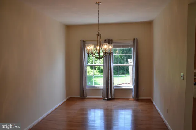 a view of a room with window wooden floor and front door