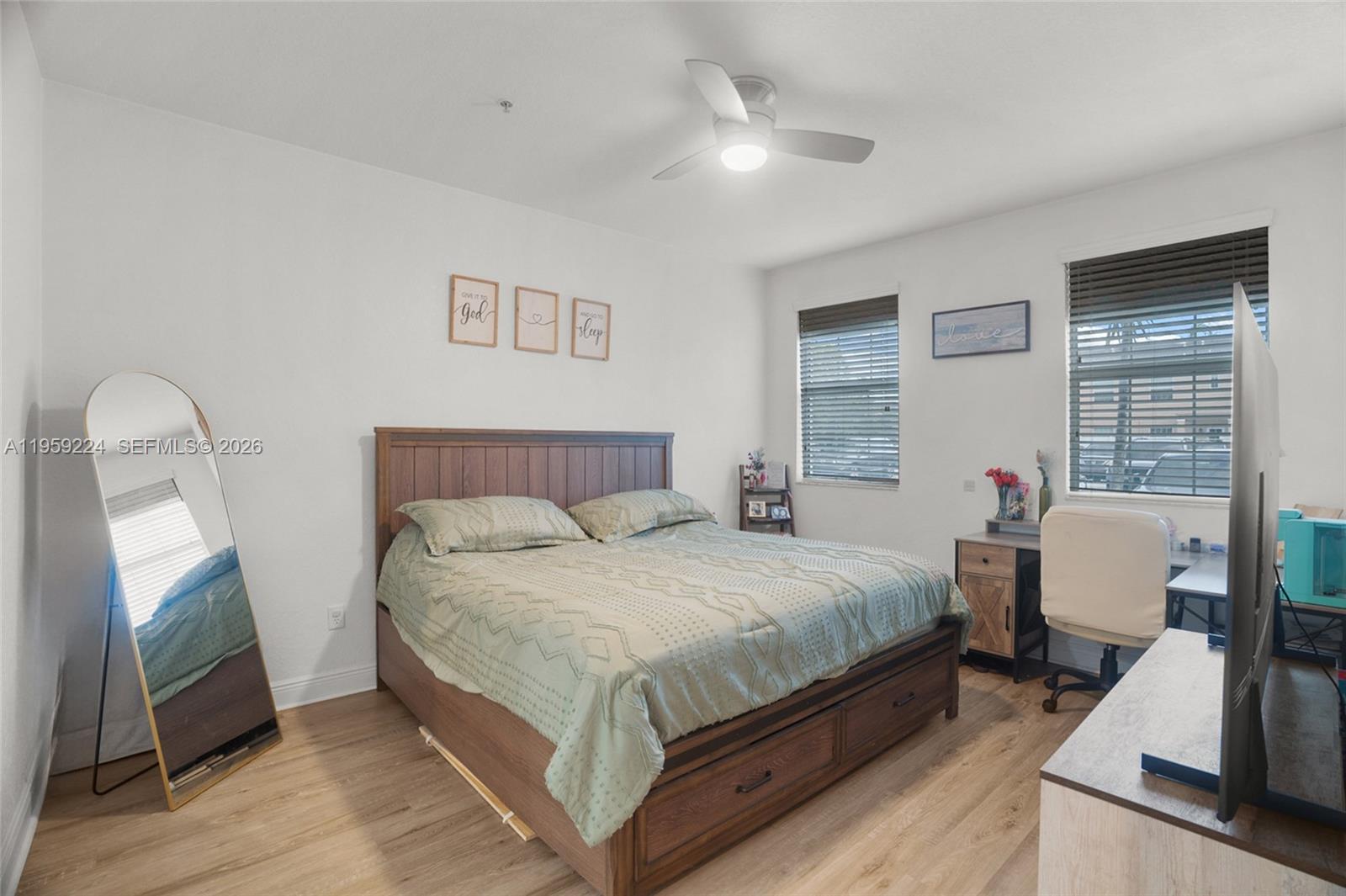 14774 Southwest 10th Street, Unit 10502 Pembroke Pines, FL 33027 - Photo 18 of 42 a bedroom with a bed wooden floor and window