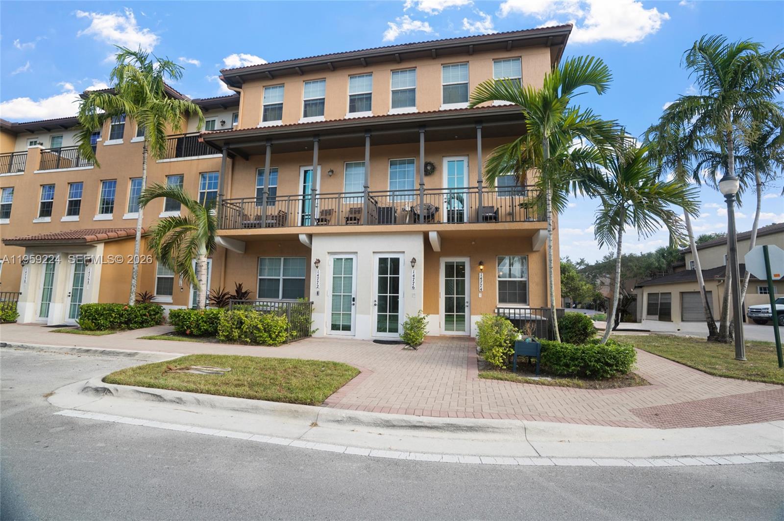 14774 Southwest 10th Street, Unit 10502 Pembroke Pines, FL 33027 - Photo 2 of 42 a front view of a residential apartment building with a yard and plants