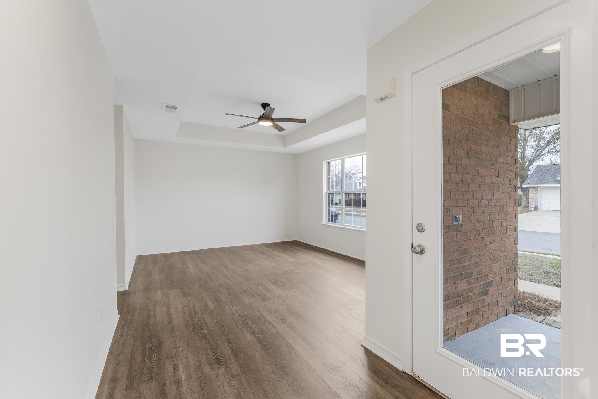 16330 Absalom Street Foley, AL 36535 - Photo 12 of 42 Spare room featuring a tray ceiling, dark wood-type flooring, and ceiling fan