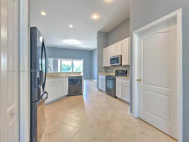 a kitchen with refrigerator and cabinets