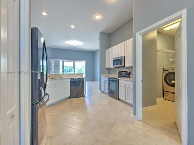 en empty room with windows and chandelier fan