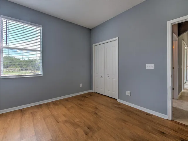 a view of a hallway with a chandelier fan and a bathroom