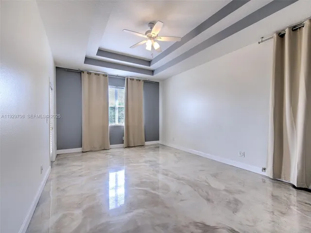 a view of a hallway with a chandelier fan and table in a room