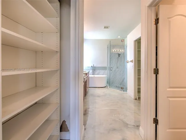 a view of walk in closet with empty racks