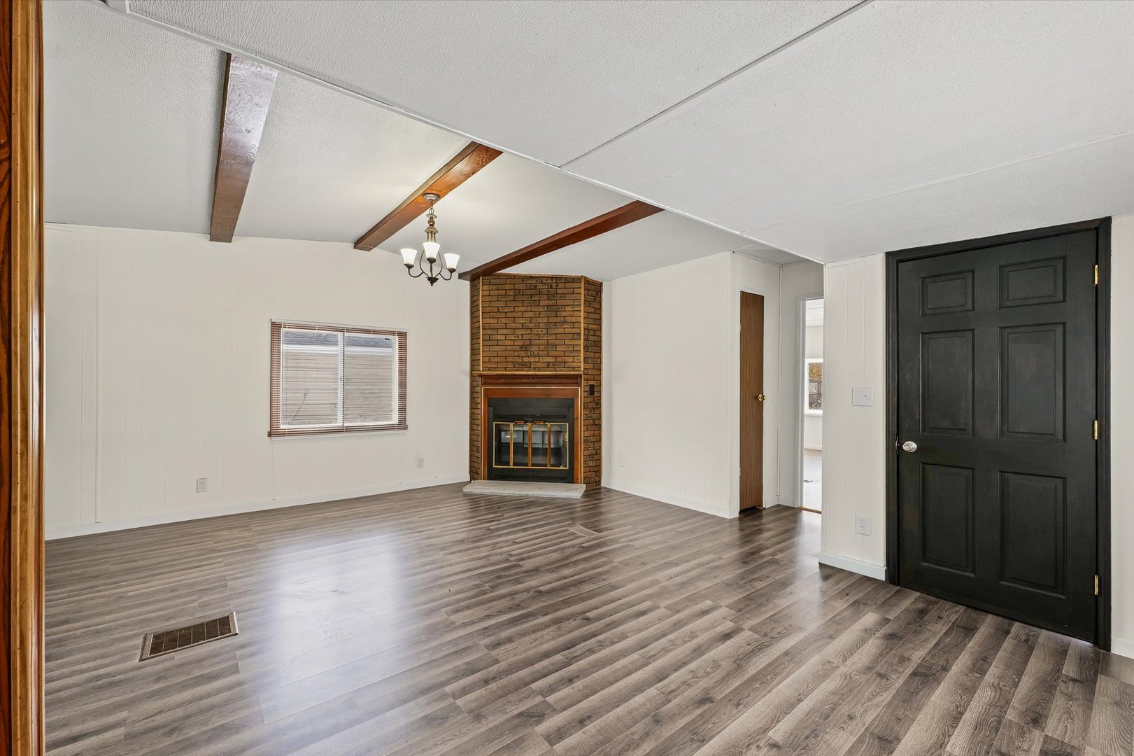 1221 Brookshire Drive, Unit 1221 Rantoul, IL 61866 - Photo 8 of 30 an empty room with wooden floor chandelier and windows