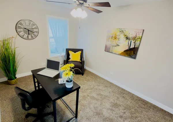 a living room with furniture and paintings on the wall