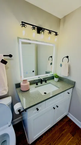 a bathroom with a granite countertop sink a mirror and shower