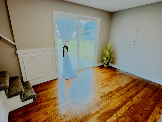 a view of a room with wooden floor and white walls