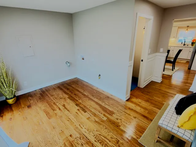 a view of a room with wooden floor and a bathroom