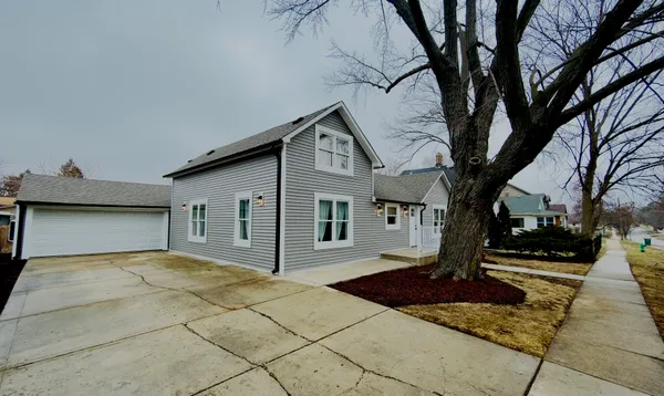 a front view of house with yard and trees around