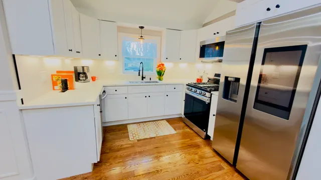 a kitchen with a sink a refrigerator and white cabinets