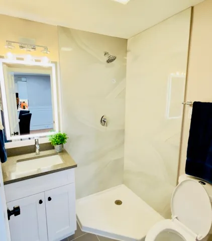 a bathroom with a sink a toilet and shower