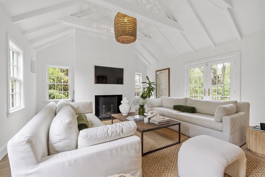 90 Coolidge Road Concord, MA 01742 - Photo 16 of 42 a living room with furniture a fireplace and a large window