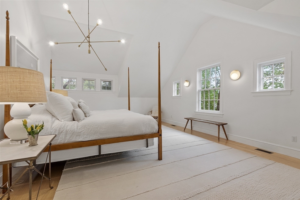 90 Coolidge Road Concord, MA 01742 - Photo 17 of 42 a spacious bedroom with a bed and a chandelier