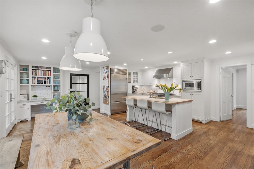 90 Coolidge Road Concord, MA 01742 - Photo 3 of 42 a kitchen with stainless steel appliances kitchen island granite countertop a table and chairs in it