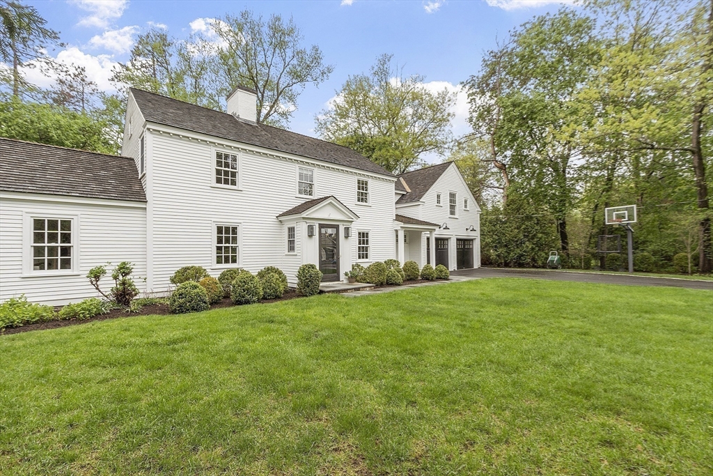 90 Coolidge Road Concord, MA 01742 - Photo 40 of 42 a view of a white house in front of a big yard with large trees