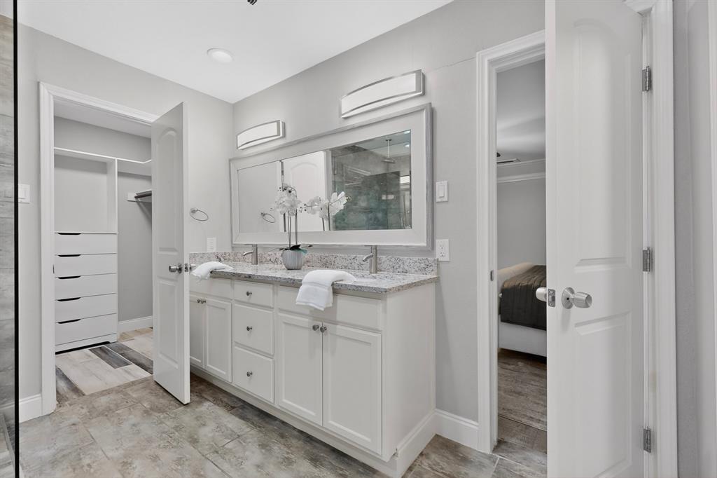 7631 Meadow Road Dallas, TX 75230 - Photo 18 of 40 A bright, elegant primary bathroom showcasing a walk-in closet and a contemporary double sink for added functionality.