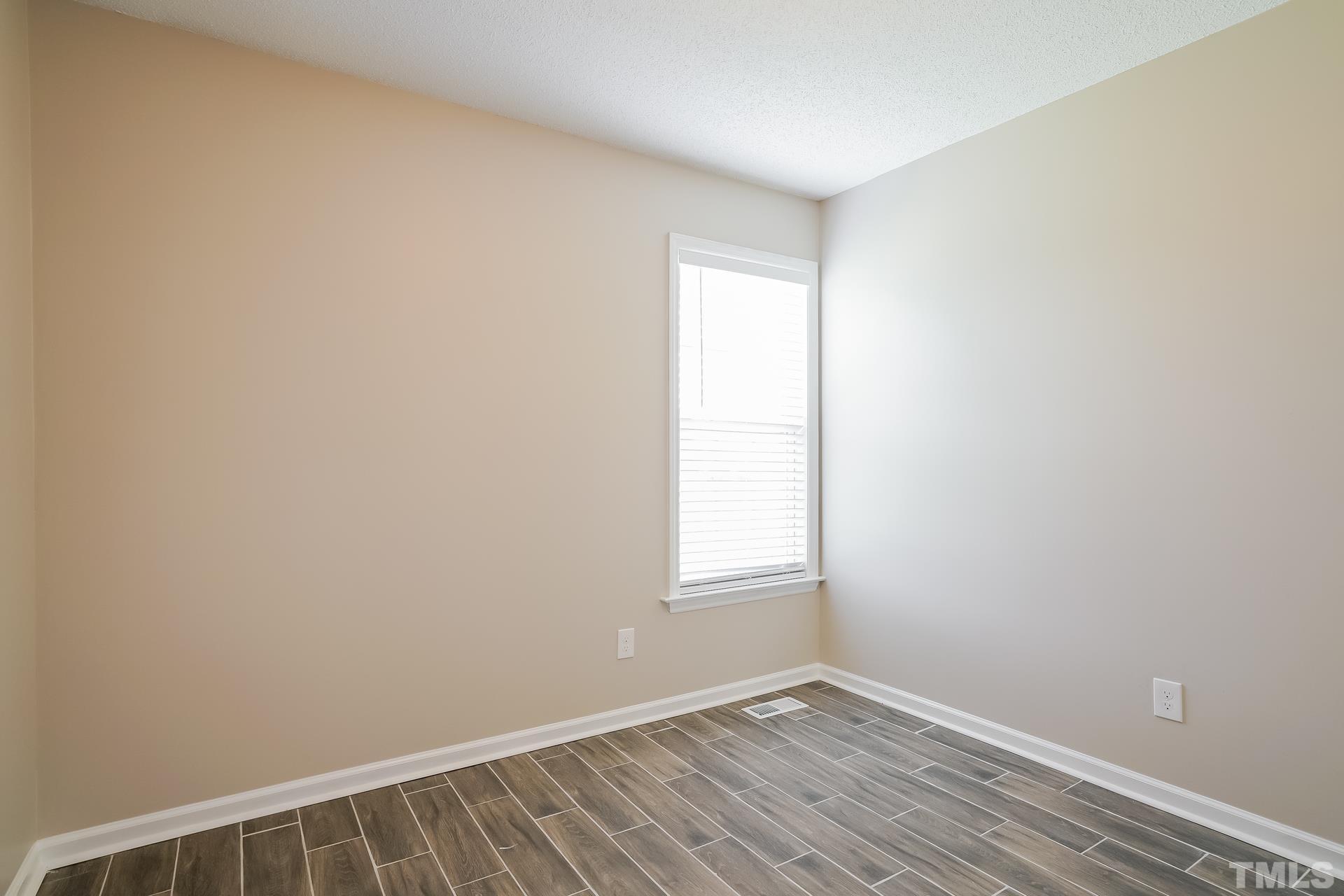 110 Impressive Lane Clayton, NC 27520 - Photo 11 of 16 an empty room with wooden floor and windows