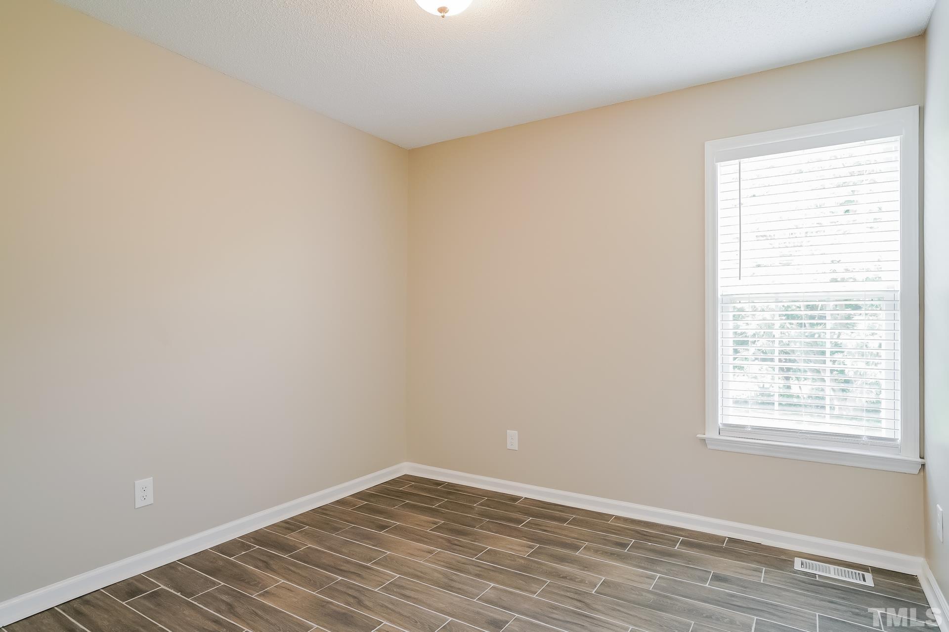 110 Impressive Lane Clayton, NC 27520 - Photo 12 of 16 wooden floor in an empty room with a window