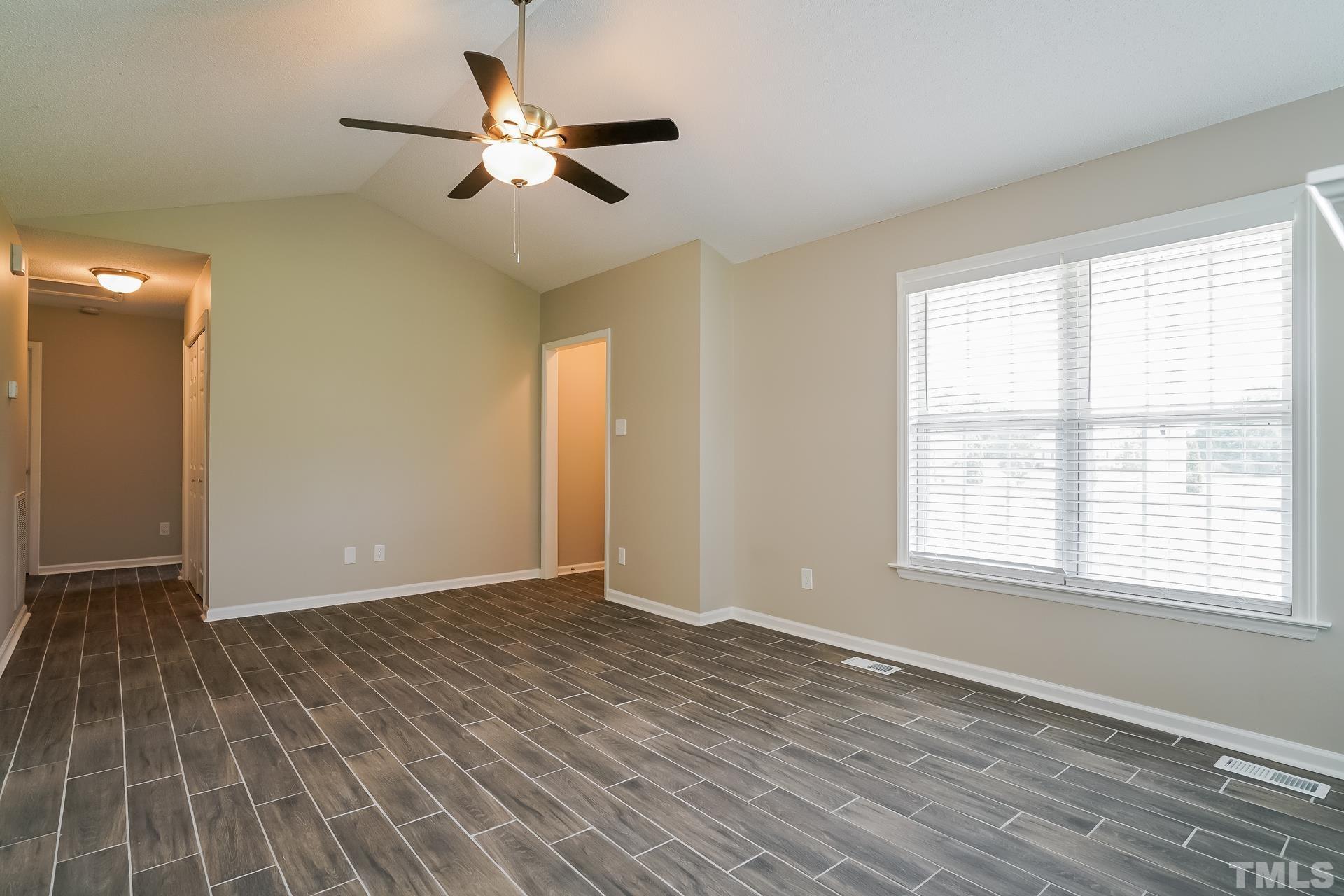 110 Impressive Lane Clayton, NC 27520 - Photo 3 of 16 a view of an empty room with wooden floor and a window