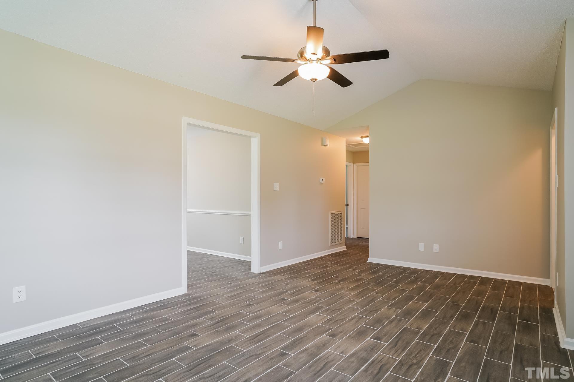 110 Impressive Lane Clayton, NC 27520 - Photo 5 of 16 an empty room with wooden floor fan and windows