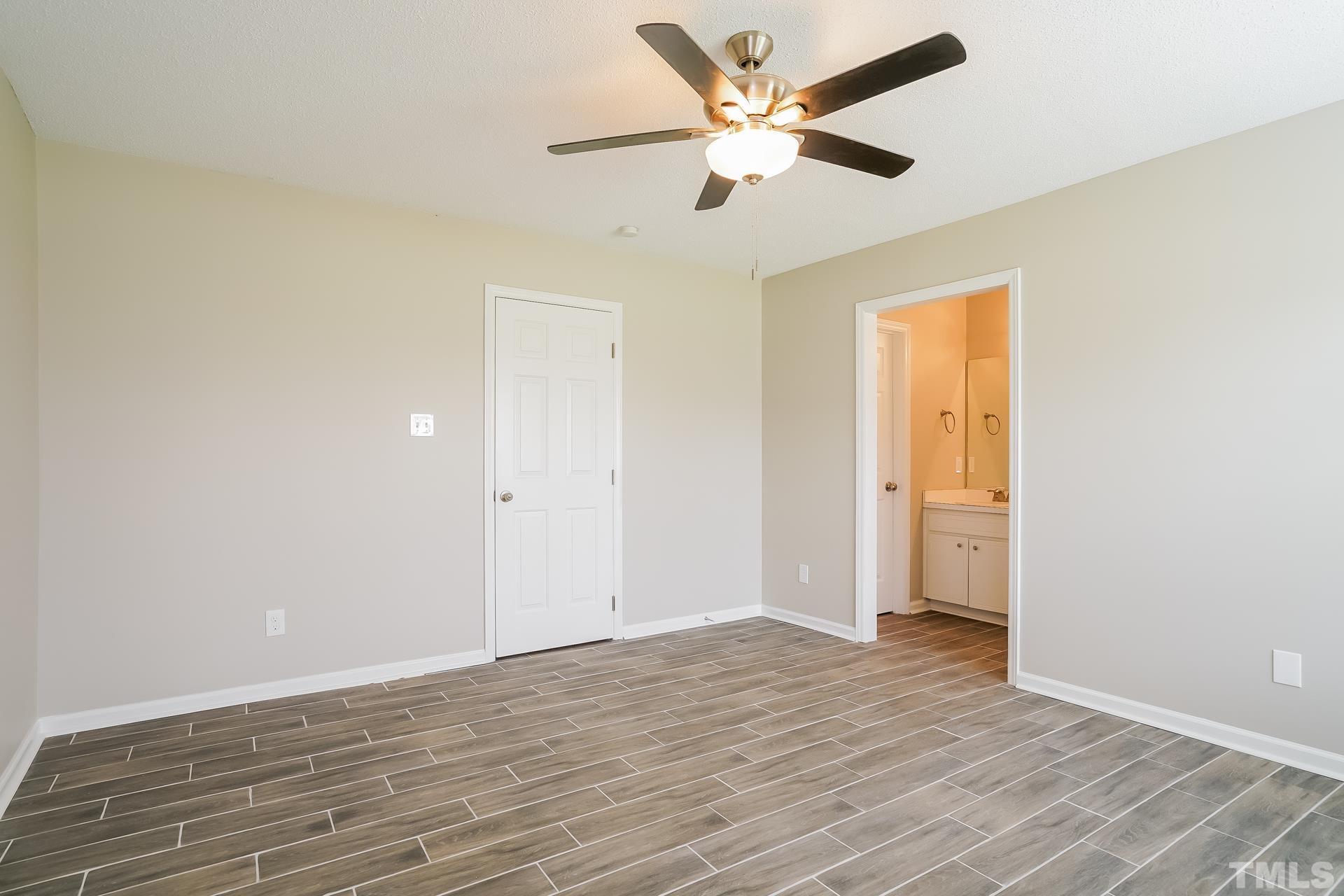 110 Impressive Lane Clayton, NC 27520 - Photo 9 of 16 an empty room with wooden floor and a ceiling fan