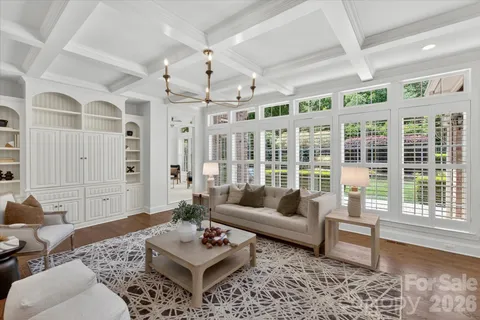 a living room with furniture wooden floor and a large window