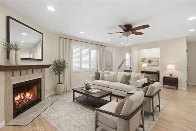 a living room with furniture a fireplace and a ceiling fan