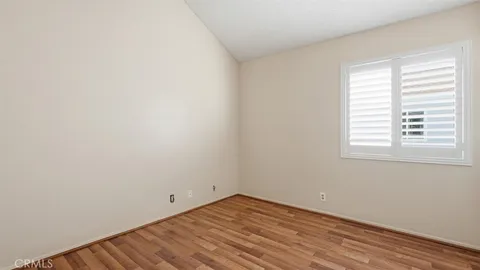 a view of a room that has wooden floor and window