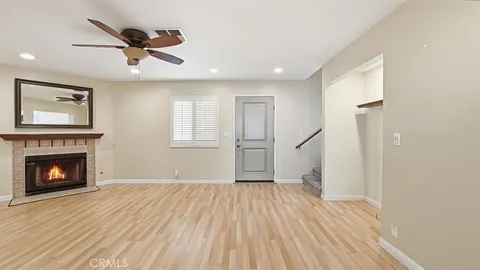 a view of empty room with wooden floor and fireplace
