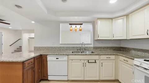 a kitchen with granite countertop a sink and cabinets