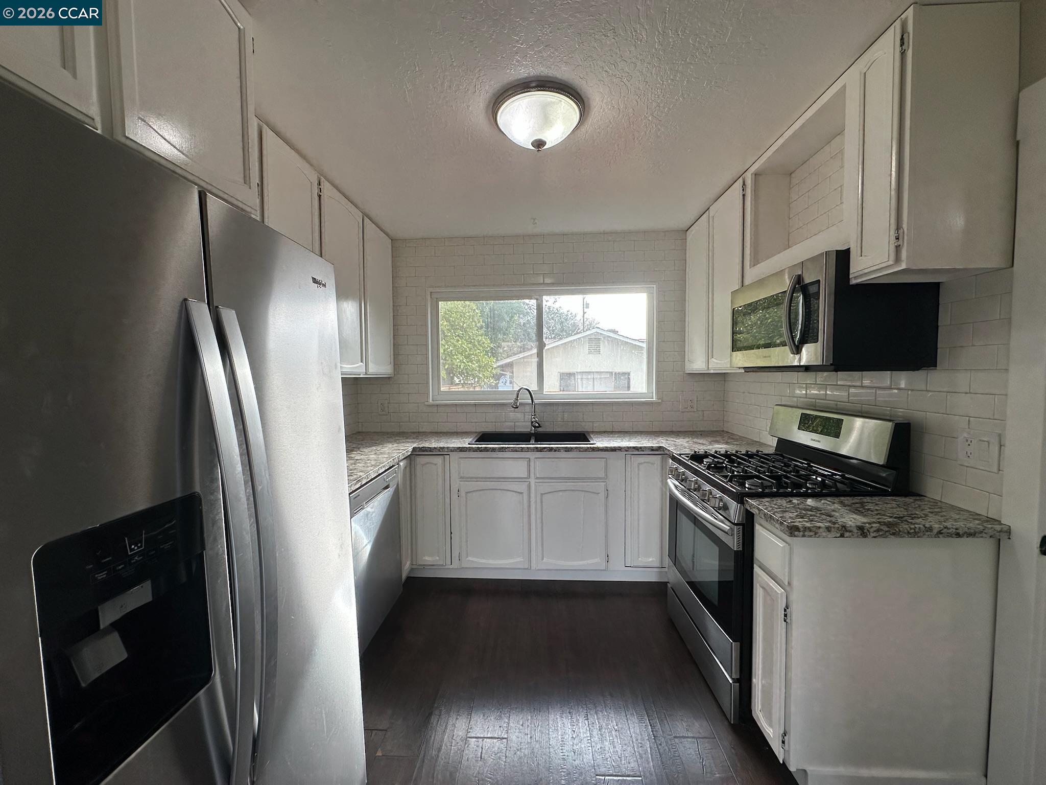 315 West 3rd Street, Unit B Antioch, CA 94509 - Photo 13 of 41 a kitchen with stainless steel appliances granite countertop a refrigerator a stove a sink and a microwave