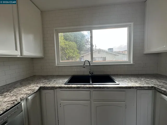a kitchen with granite countertop a sink and a window
