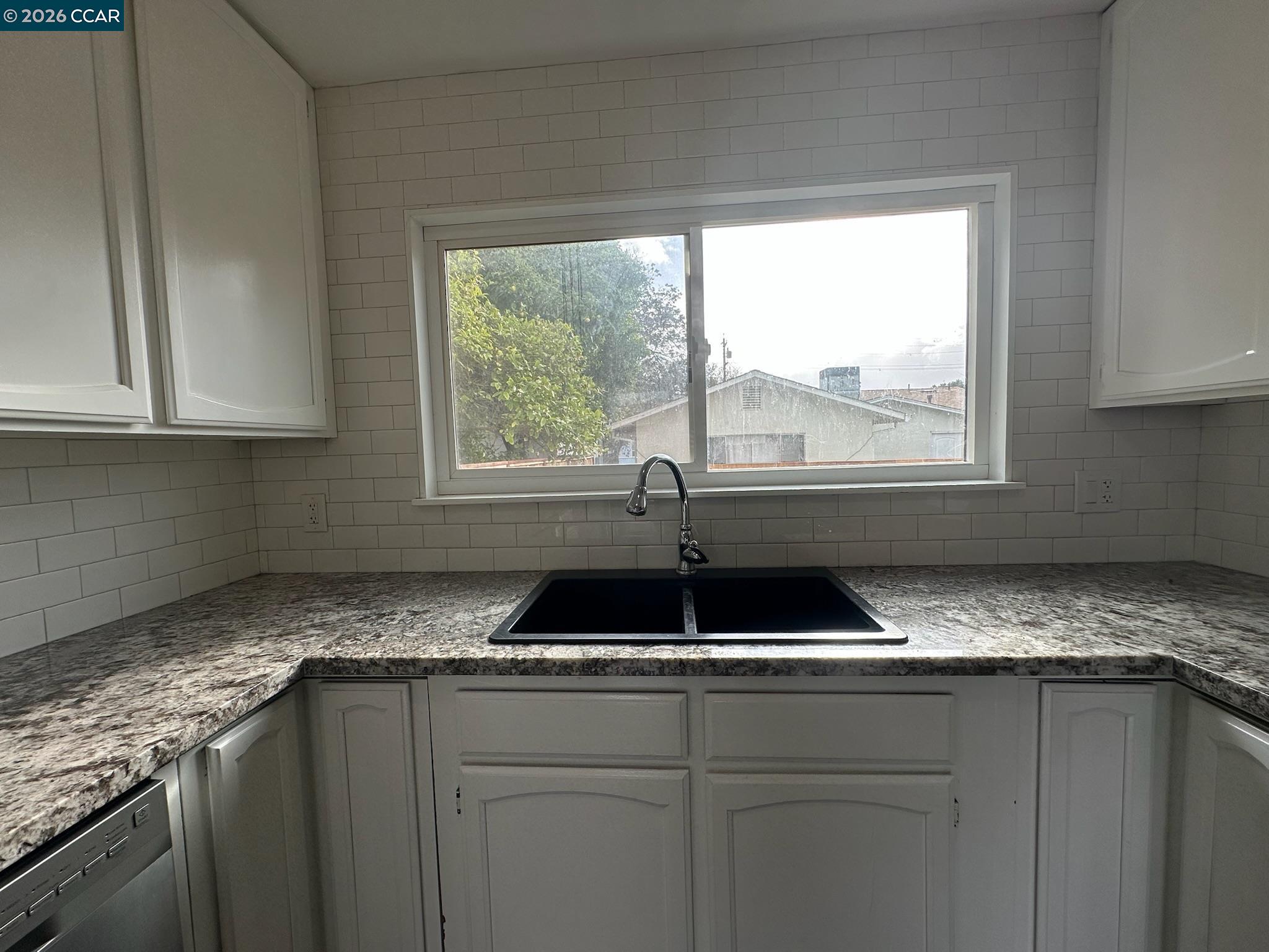 315 West 3rd Street, Unit B Antioch, CA 94509 - Photo 14 of 41 a kitchen with granite countertop a sink and a window