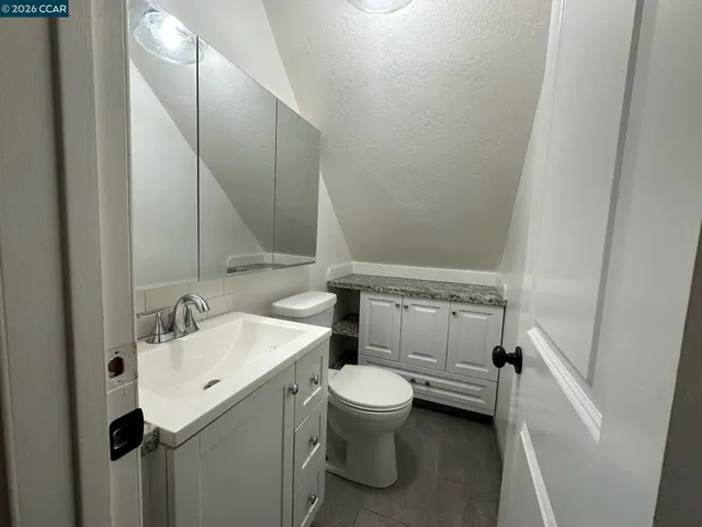 a bathroom with a sink and mirror with toilet